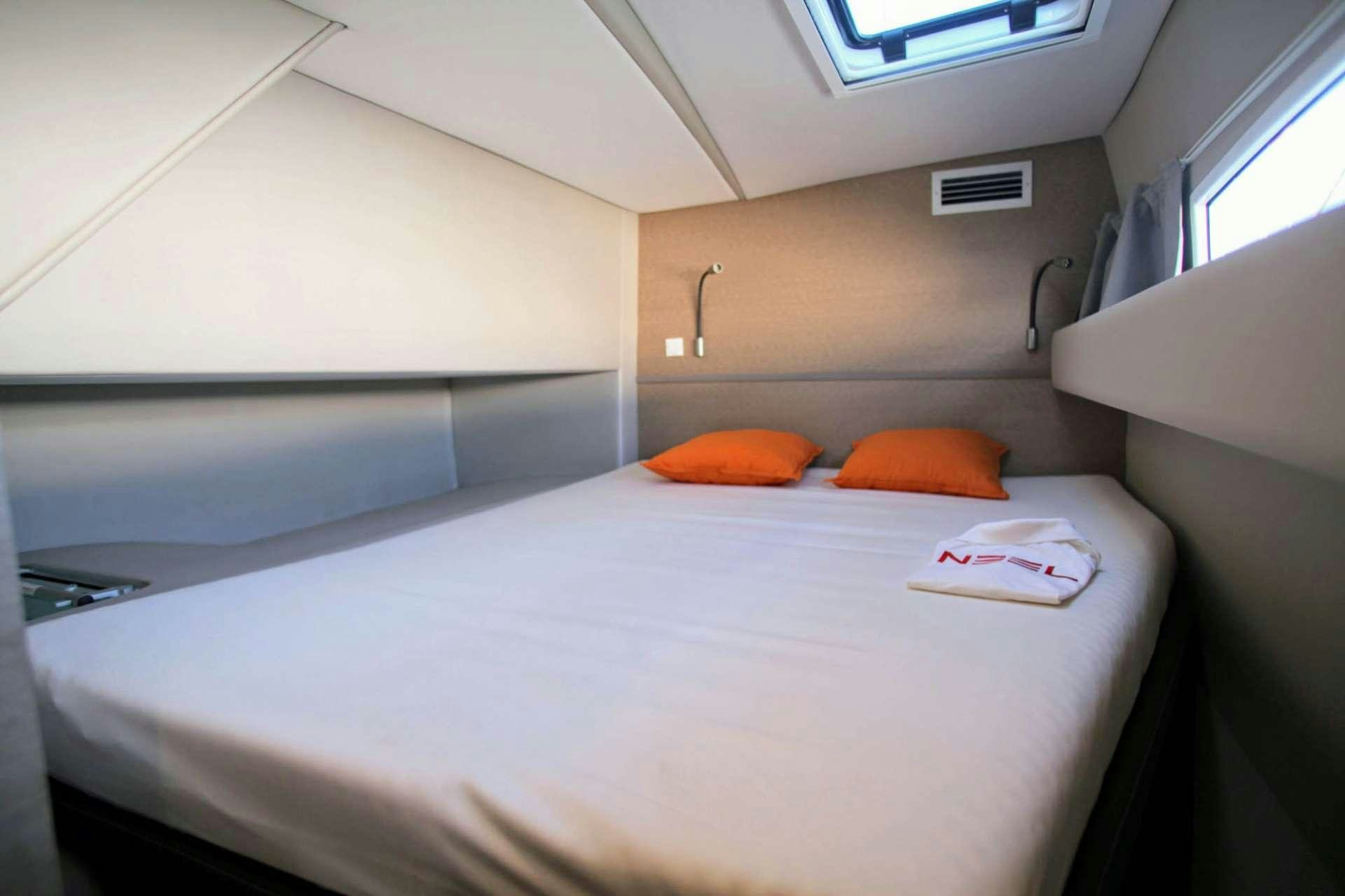 a white bed with a pillow on it aboard TRILOGY Yacht for Charter