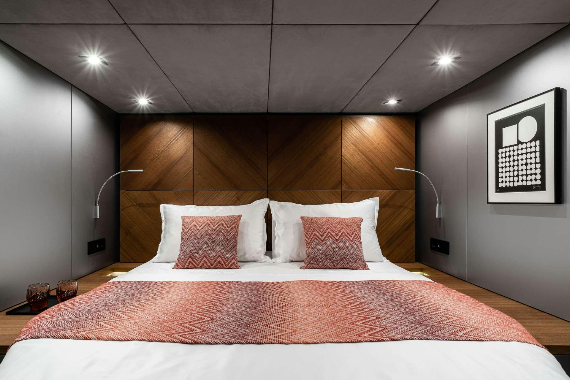 a bed with a red sheet aboard E SUPERCAT Yacht for Charter