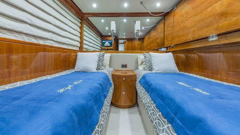 a room with beds and a wood wall aboard HIGH RISE Yacht for Charter
