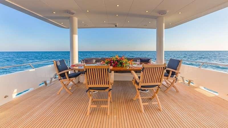 a deck with chairs and tables on it aboard HIGH RISE Yacht for Charter