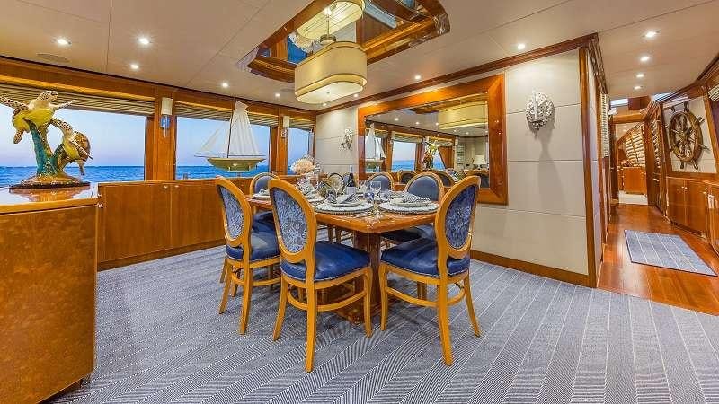 a dining room with a table and chairs aboard HIGH RISE Yacht for Charter