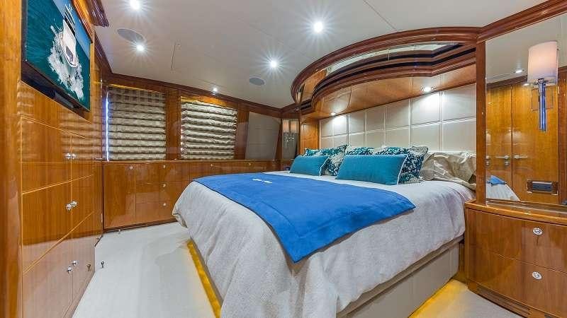 a bedroom with a bed and a dresser aboard HIGH RISE Yacht for Charter