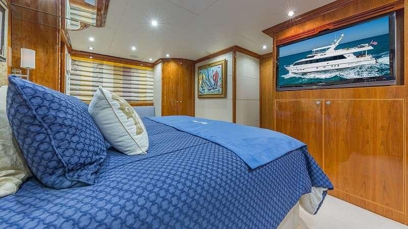 a bed with blue sheets aboard HIGH RISE Yacht for Charter