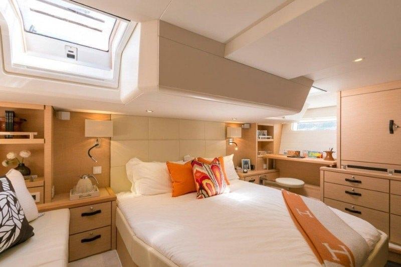 a bedroom with a bed and a desk aboard JEANNEAU 64 Yacht for Charter