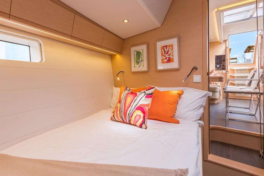 a bed with pillows on it aboard JEANNEAU 64 Yacht for Charter