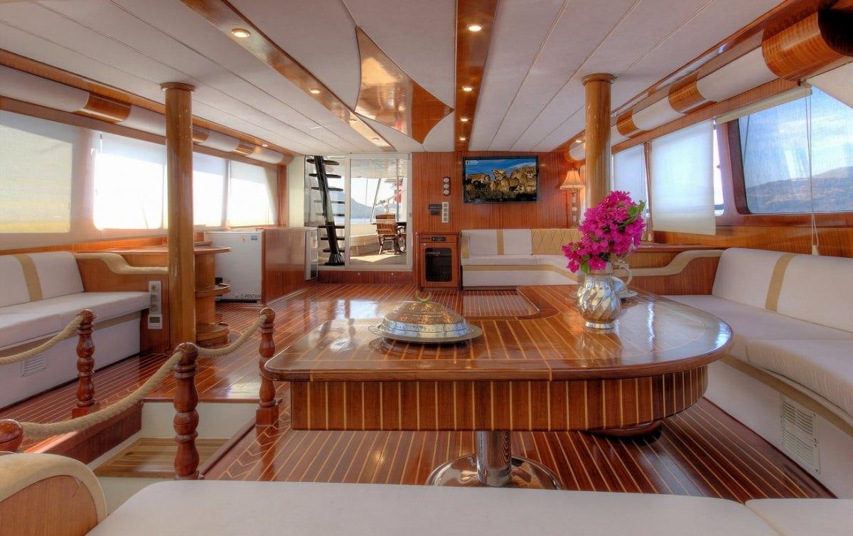 a living room with a table and couches aboard ANGELO II Yacht for Charter