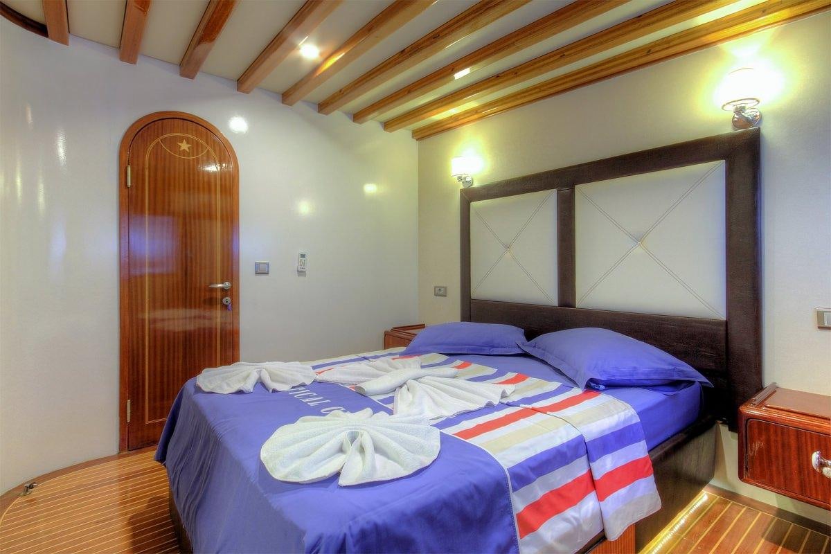 a bedroom with a bed and a door aboard ANGELO II Yacht for Charter