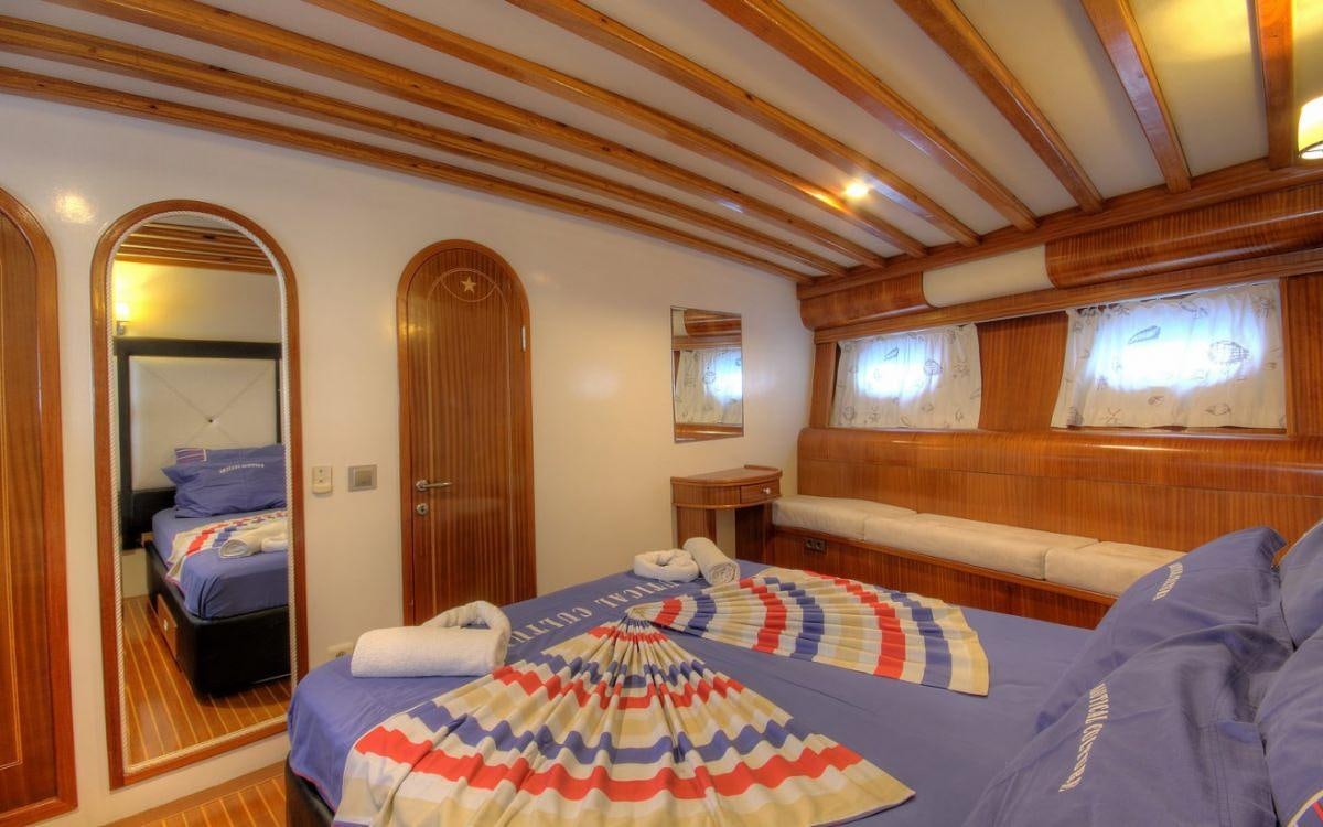 a room with a bed and a mirror aboard ANGELO II Yacht for Charter