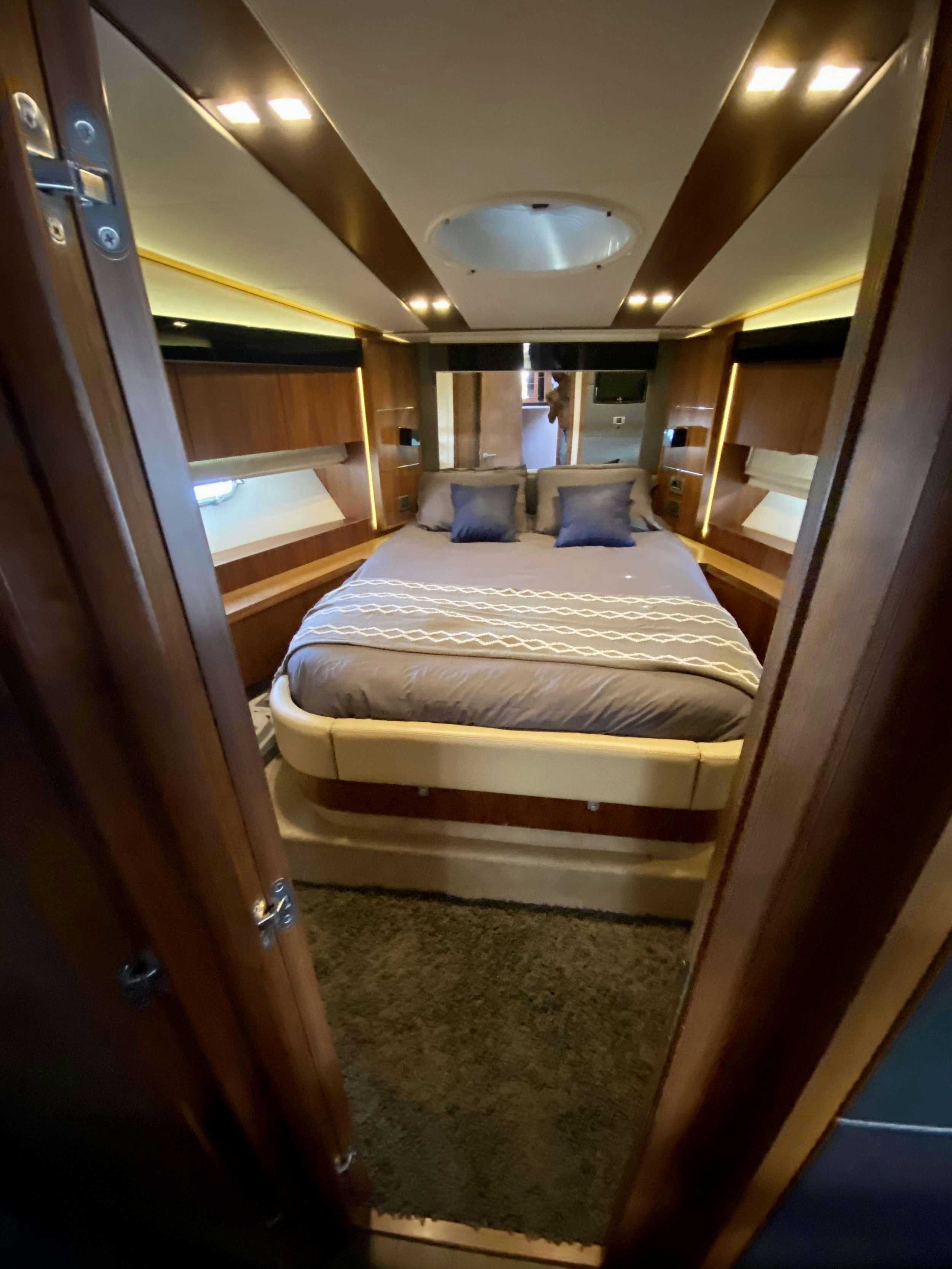 a room with a bed and a mirror aboard ALMA Yacht for Charter
