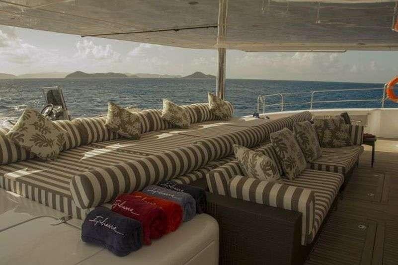a couch with pillows and blankets aboard IPHARRA Yacht for Charter