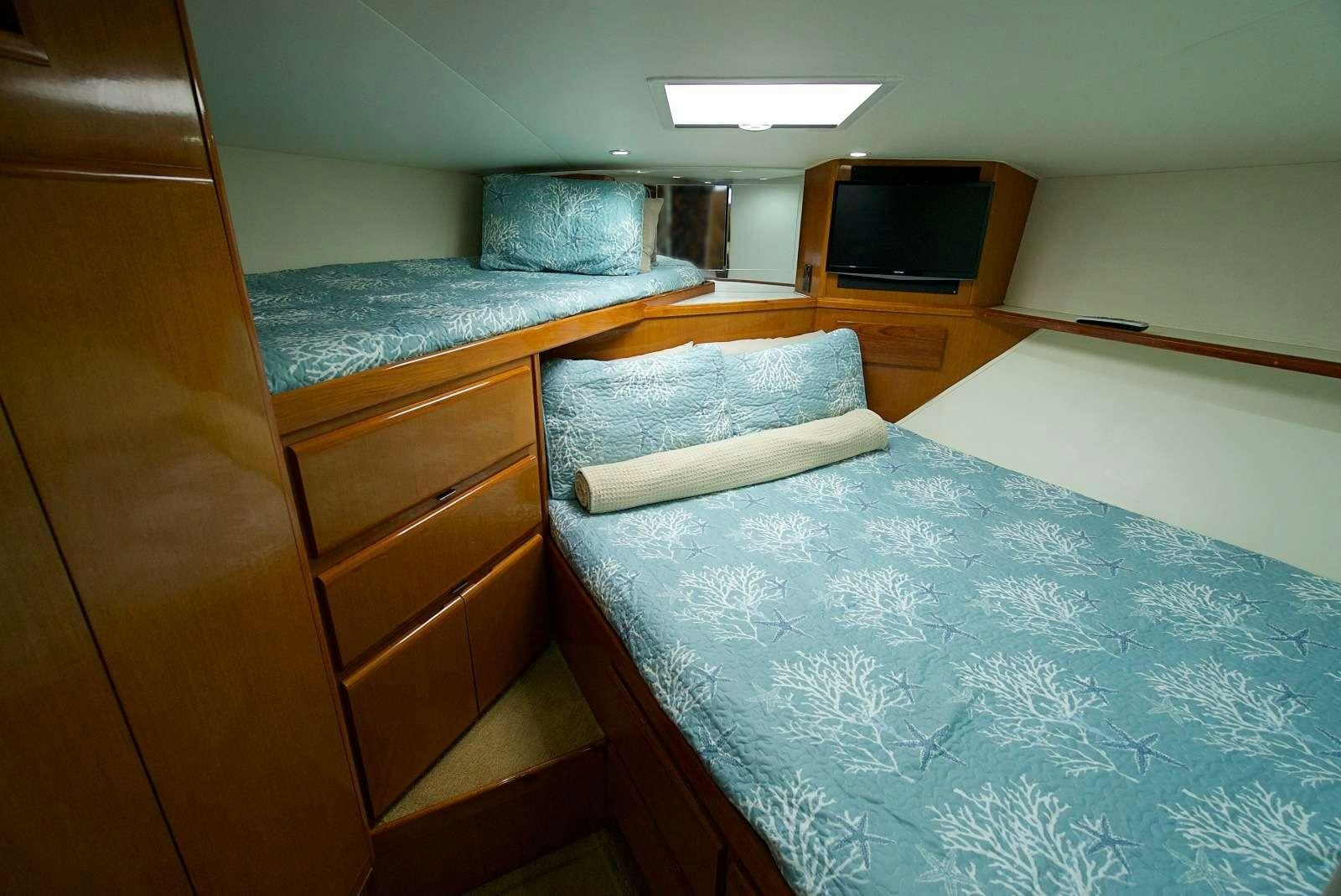 a room with a bed and television aboard MISS KETHLEEN Yacht for Charter