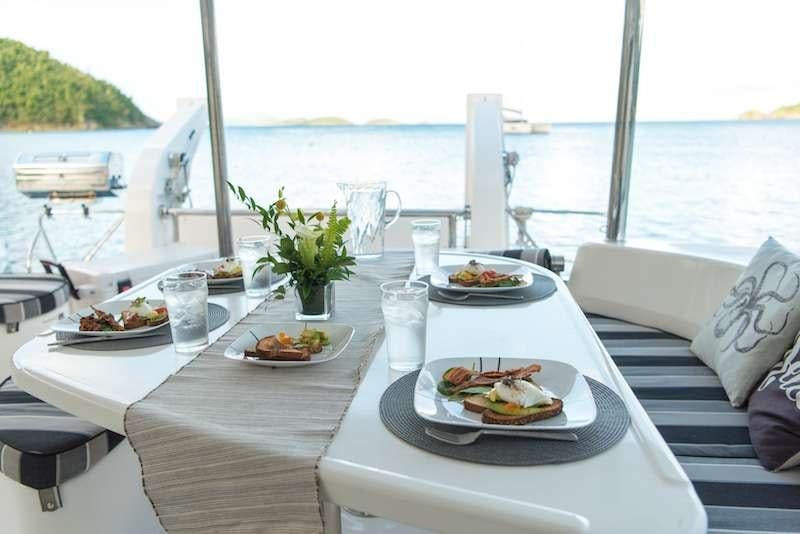 a table with plates of food on it aboard ISLAND R&amp;R Yacht for Charter
