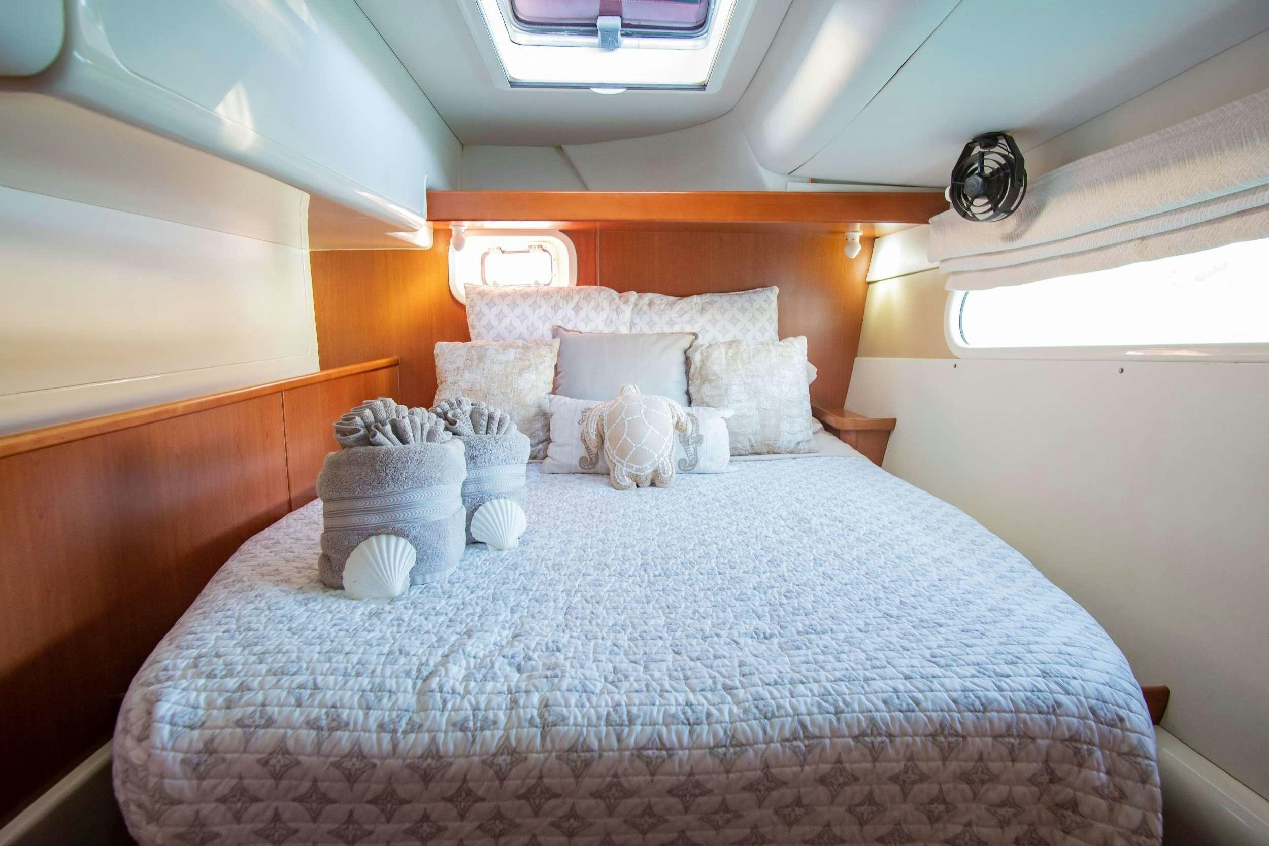 a bed with white pillows aboard ISLAND R&amp;R Yacht for Charter