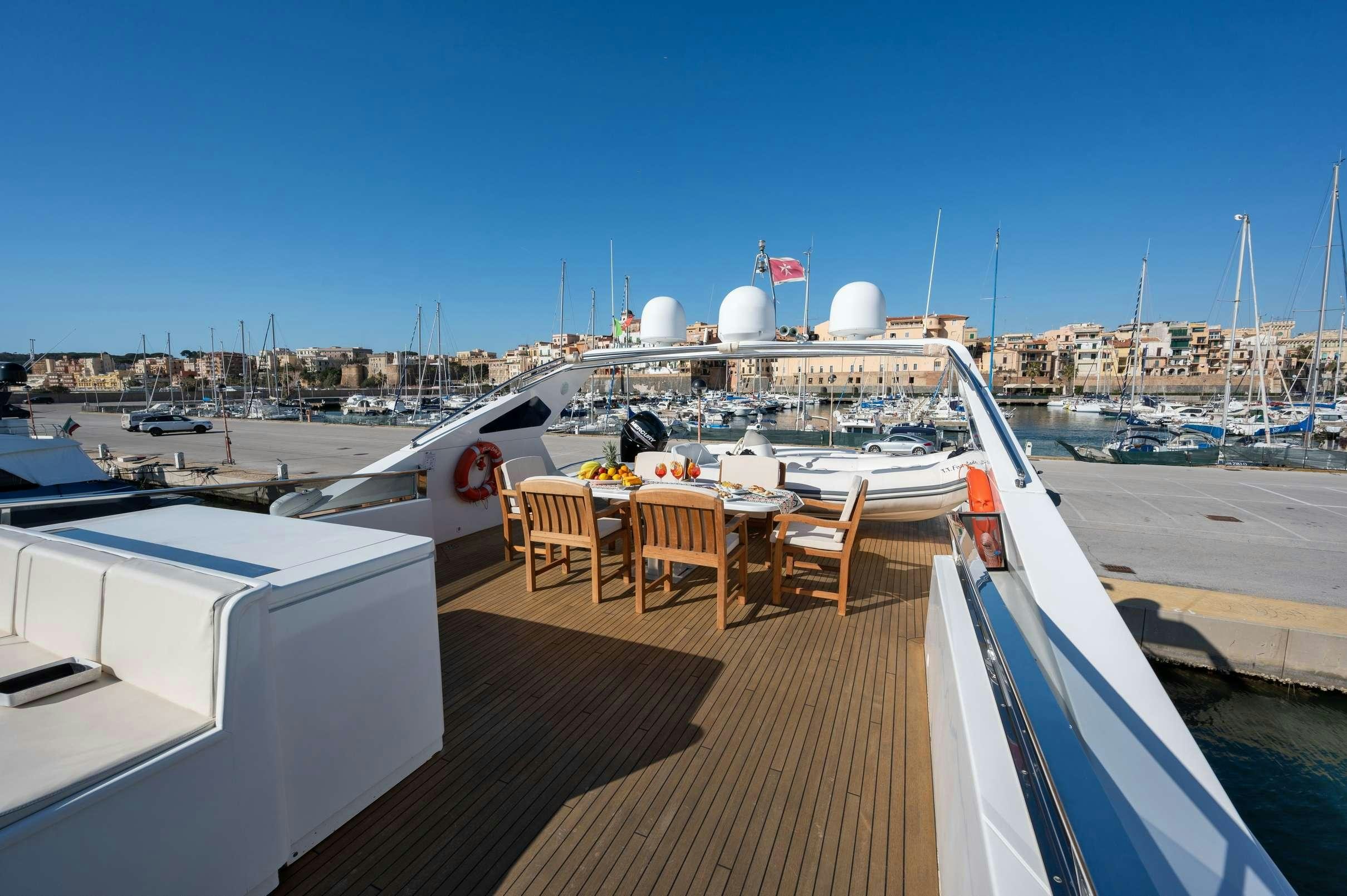 a deck with a table and chairs on it aboard FIRST LADY II Yacht for Charter