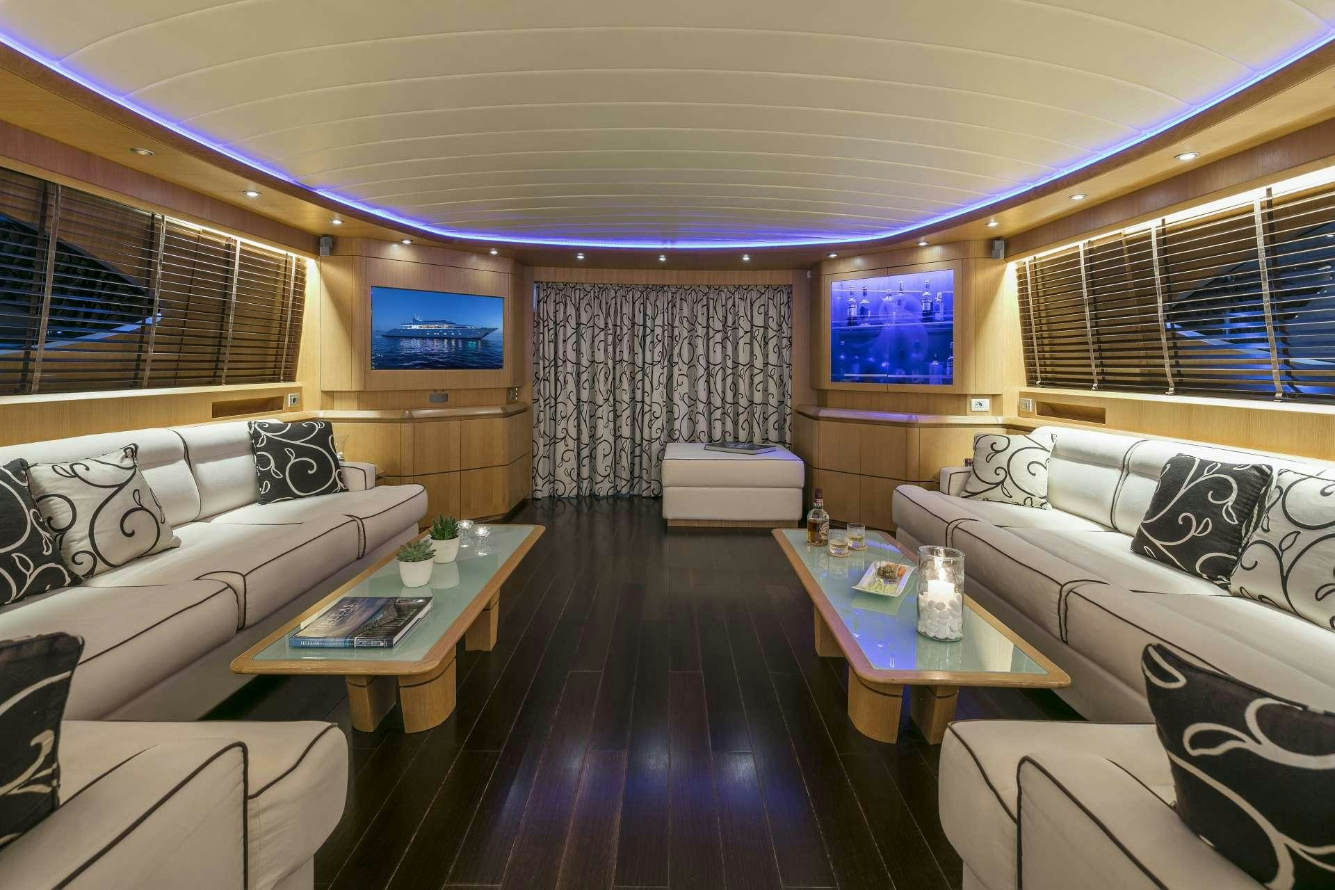 a room with a couch and a table and a television aboard ANASA Yacht for Charter