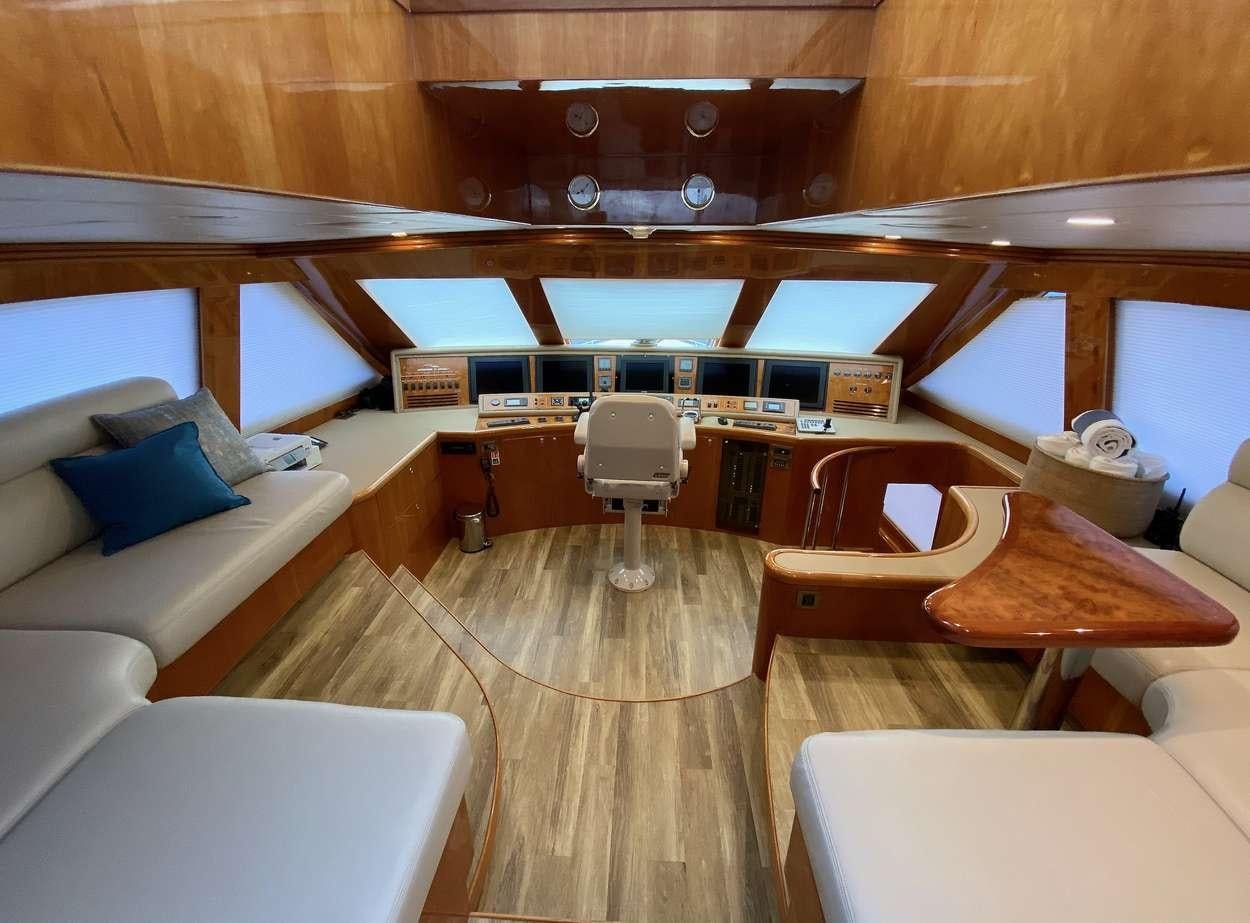 a room with a wood ceiling and a wood table with chairs and a couch aboard BRANDI WINE Yacht for Charter