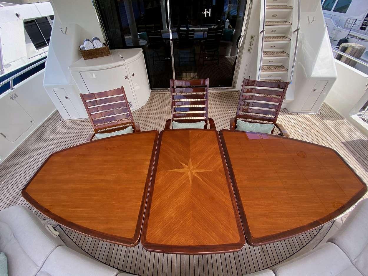 a deck with a table and chairs aboard BRANDI WINE Yacht for Charter