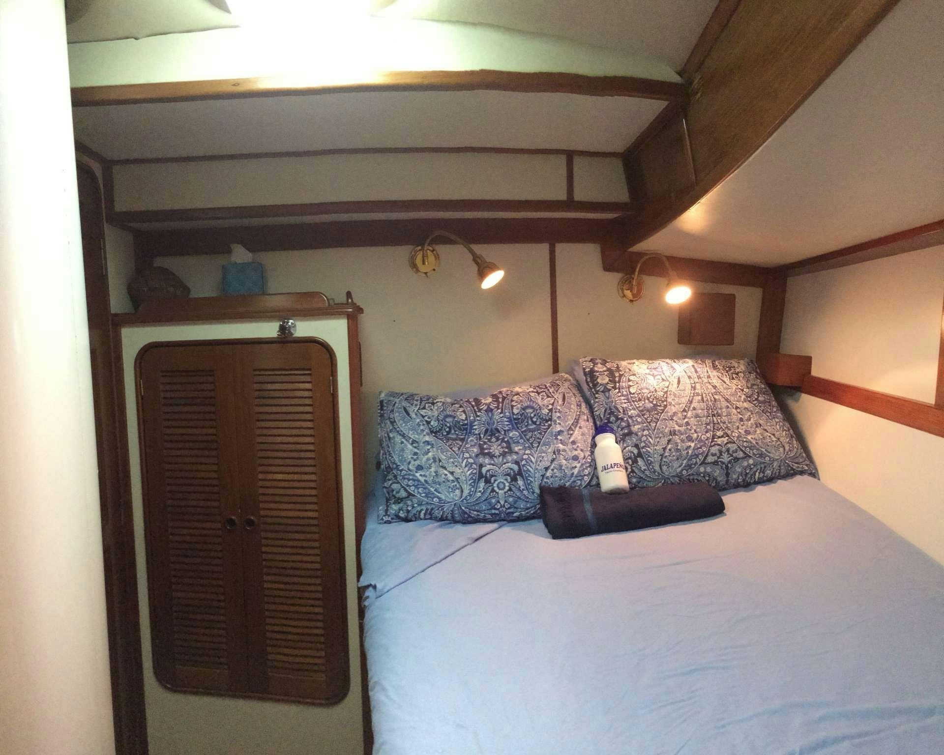 a bed with a wood headboard aboard JALAPE&Ntilde;O Yacht for Charter