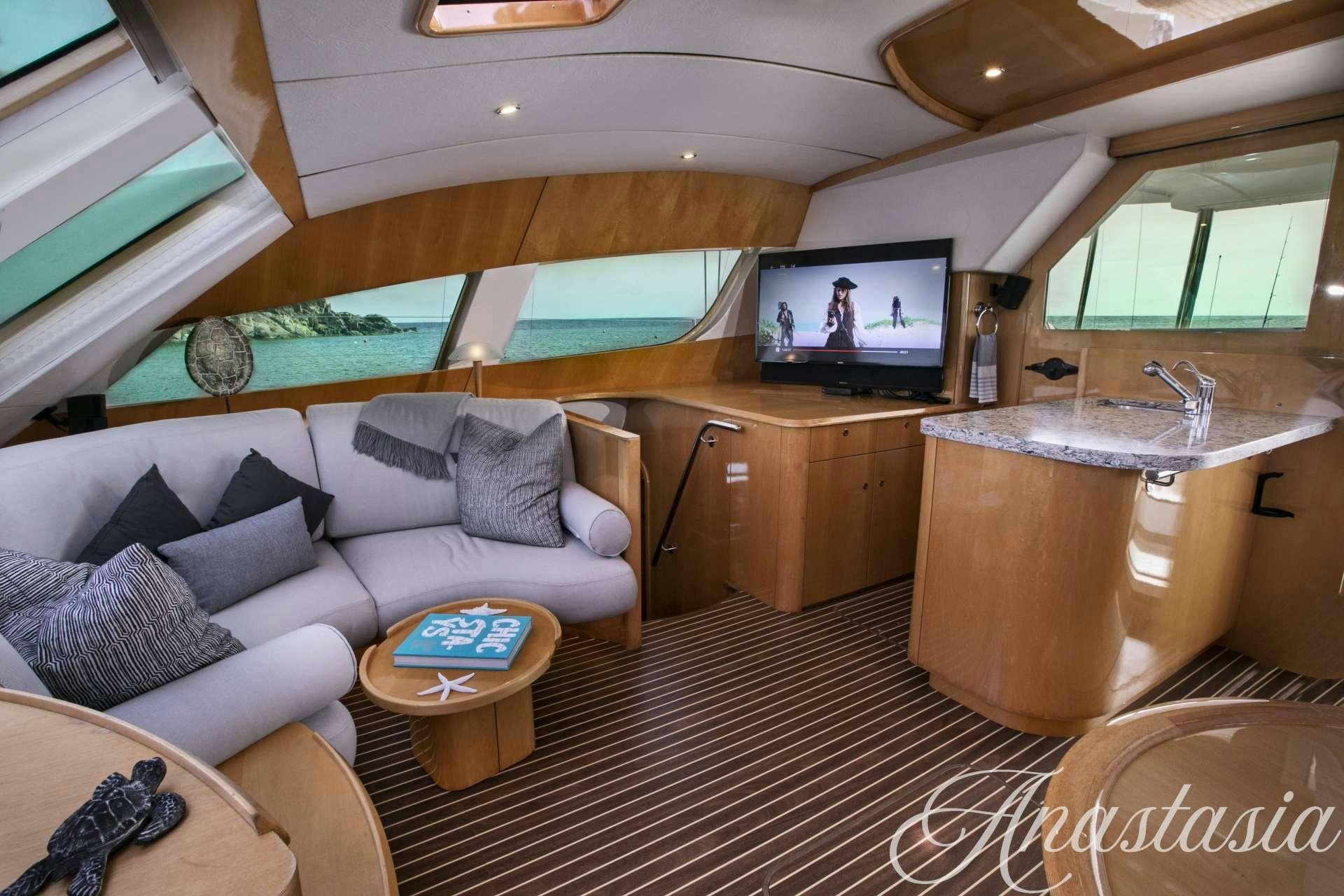 a living room with a large sofa and a television aboard ANASTASIA Yacht for Charter