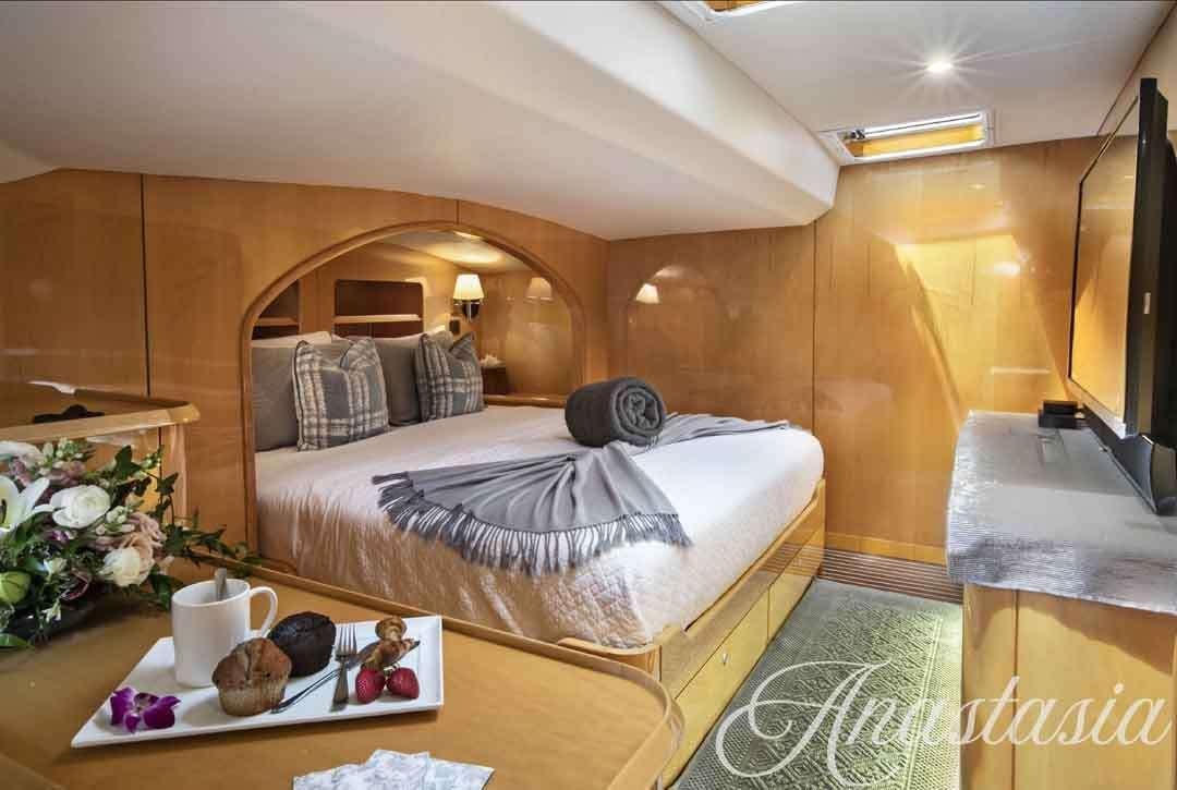 a bedroom with a bed and coffee table aboard ANASTASIA Yacht for Charter