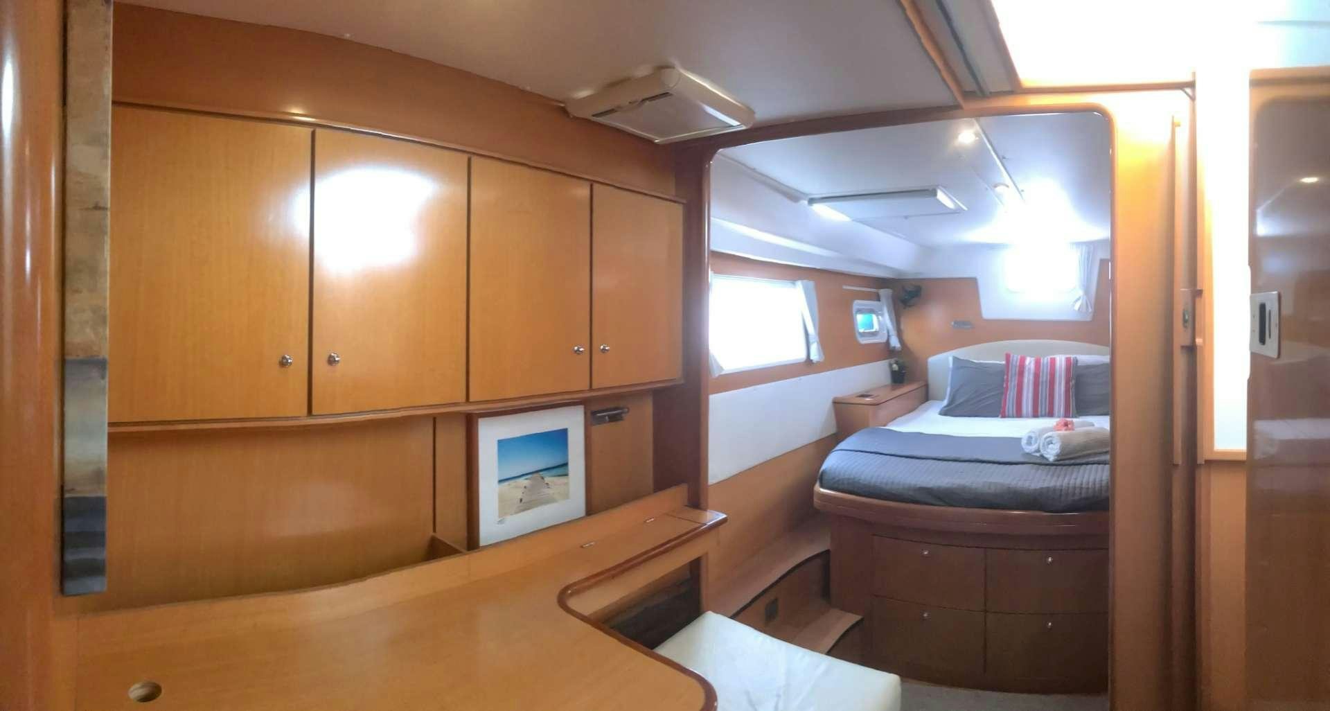 a room with a bed and a desk aboard DORIS Yacht for Charter