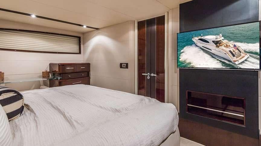 a bedroom with a bed and a television aboard LADY H Yacht for Charter