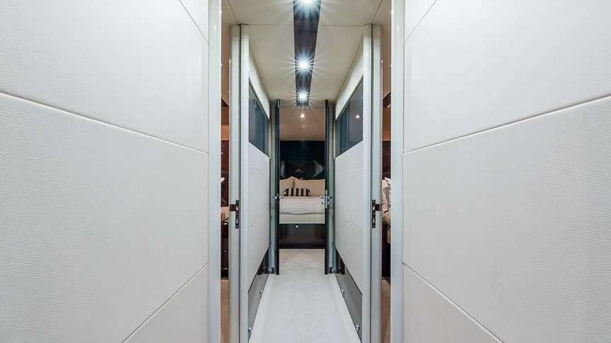 a hallway with a bed and a chair aboard LADY H Yacht for Charter