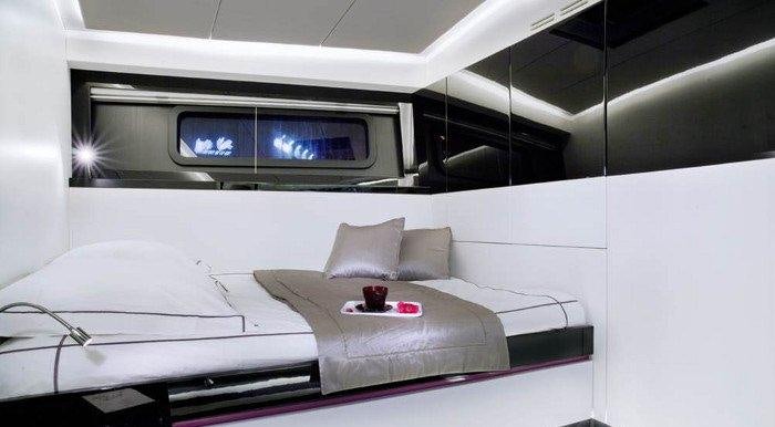 a room with a bed and a table aboard NOMAD IV Yacht for Charter