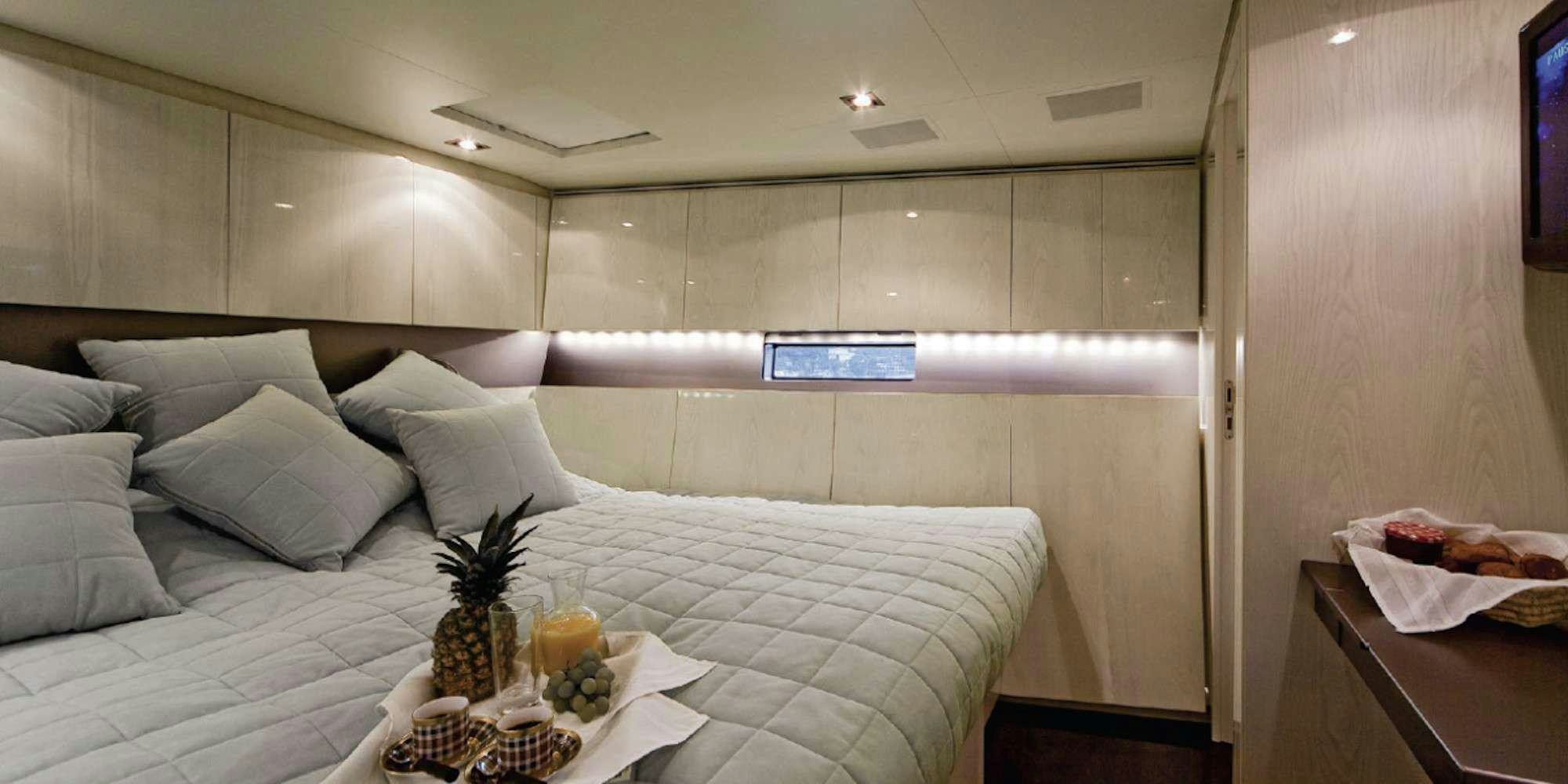 a bed with a white bed spread aboard AESOP Yacht for Charter