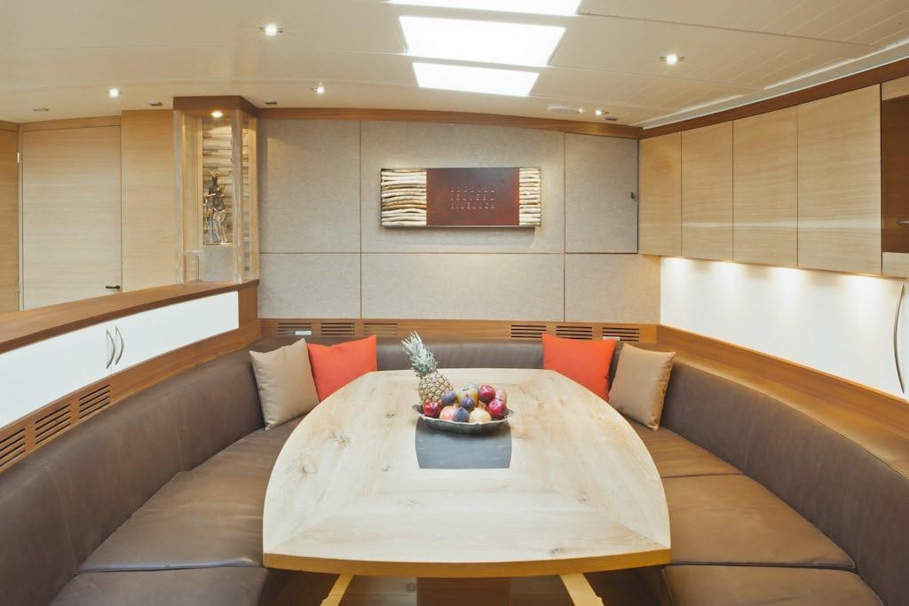 a room with a couch and a table with a bowl of fruit on it aboard HELENE Yacht for Charter