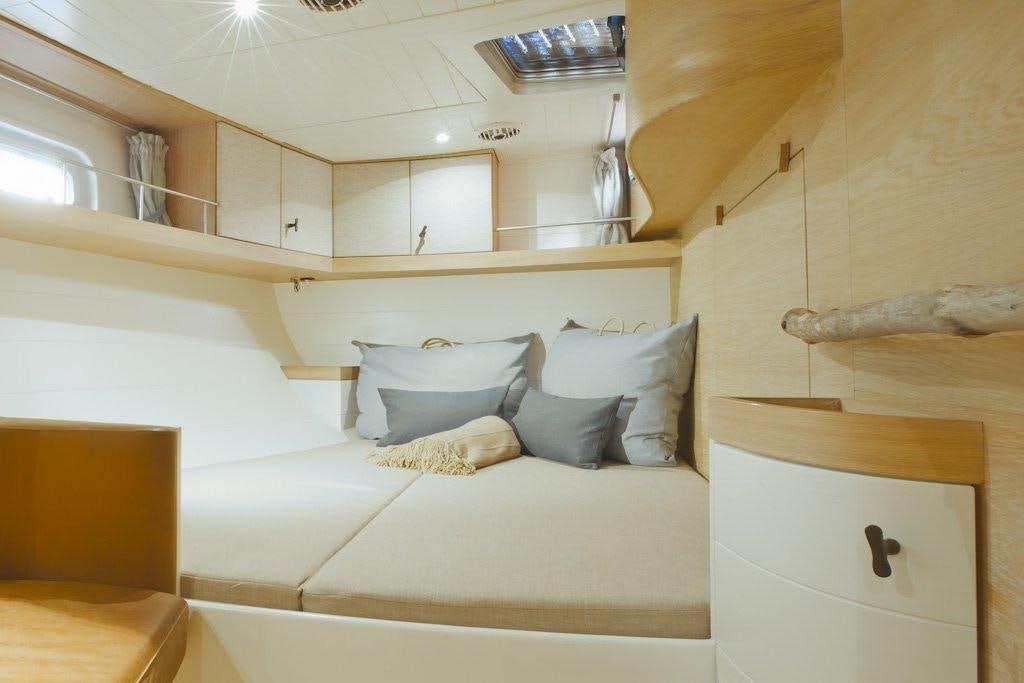 a room with a bed and a shelf aboard HELENE Yacht for Charter