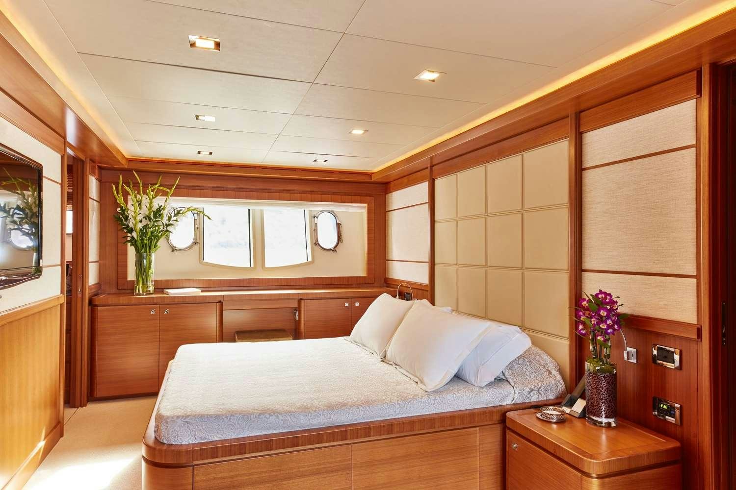 a bedroom with a bed and a plant in the corner aboard BEST OFF Yacht for Charter
