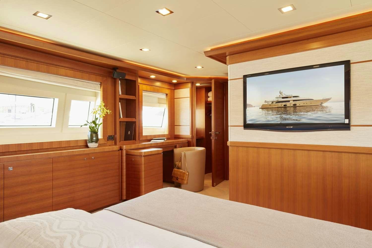a room with a bed and a television aboard BEST OFF Yacht for Charter