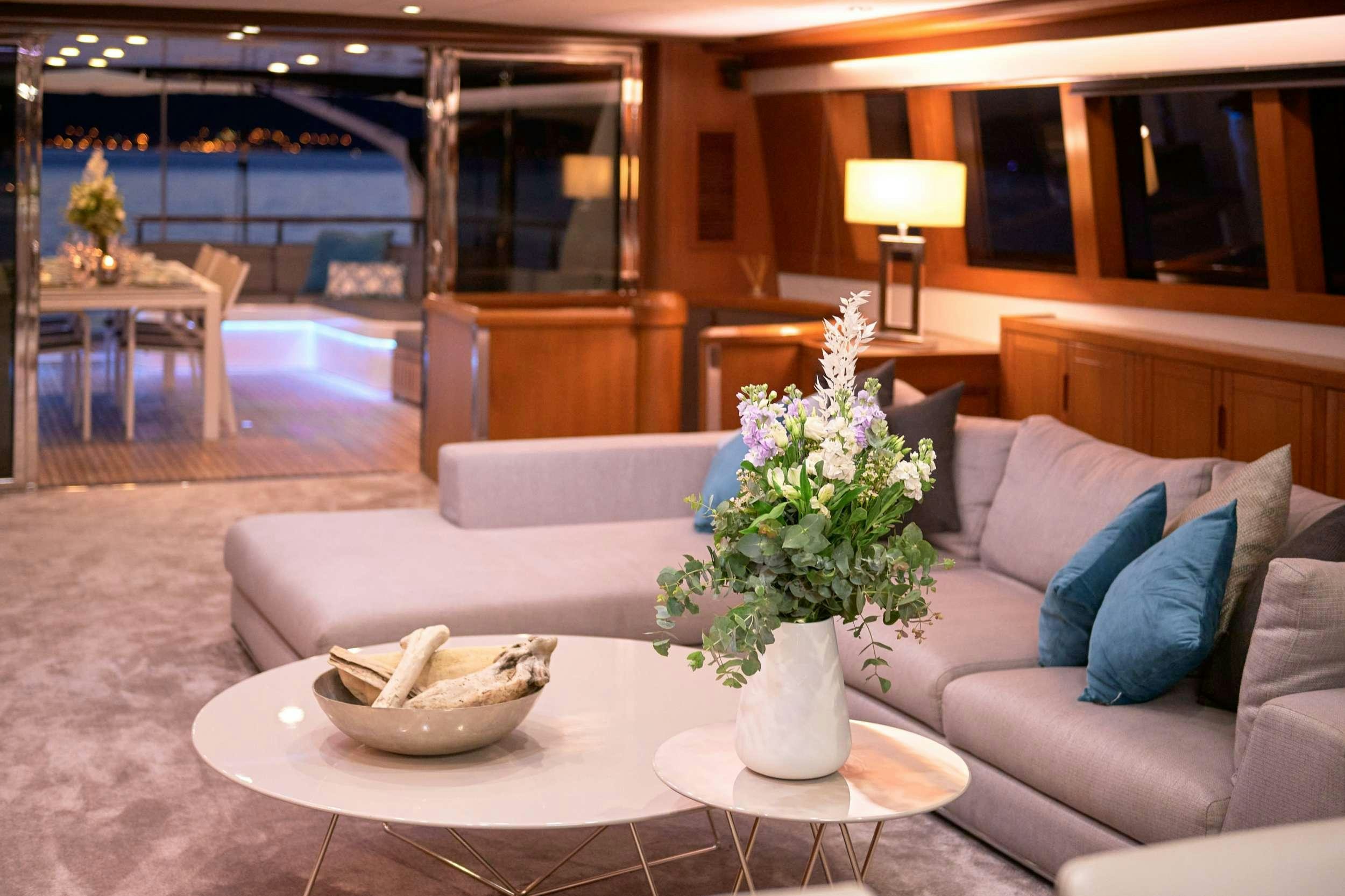 a white couch with a white coffee table and a white coffee table with blue pillows and a white aboard SAN LIMI Yacht for Charter