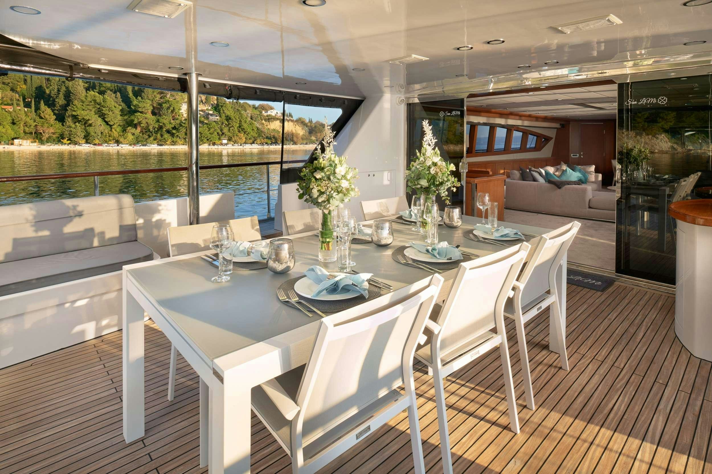 a table set with chairs and a couch aboard SAN LIMI Yacht for Charter