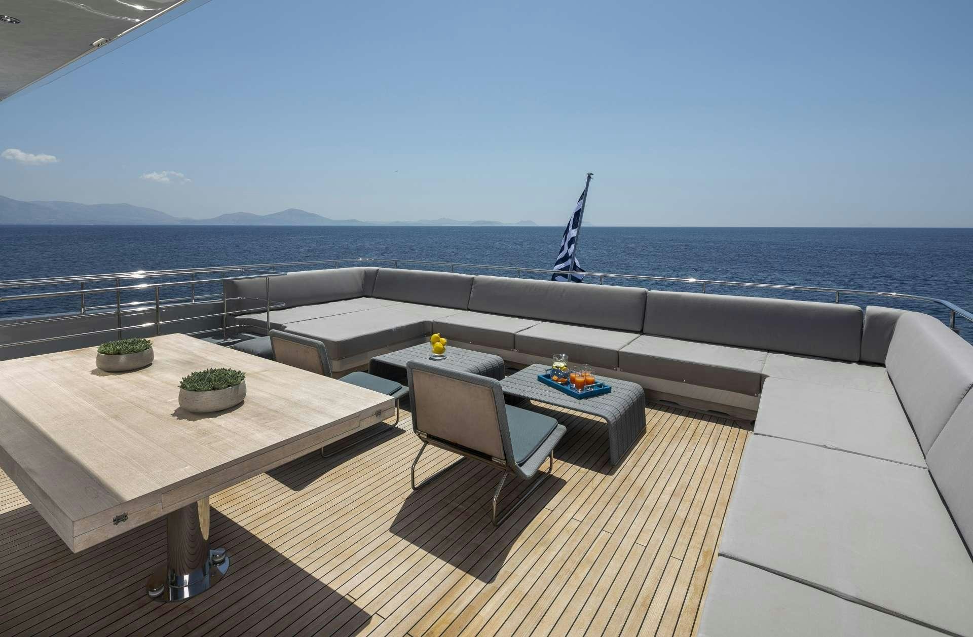 a deck with a table and chairs aboard BILLA Yacht for Charter
