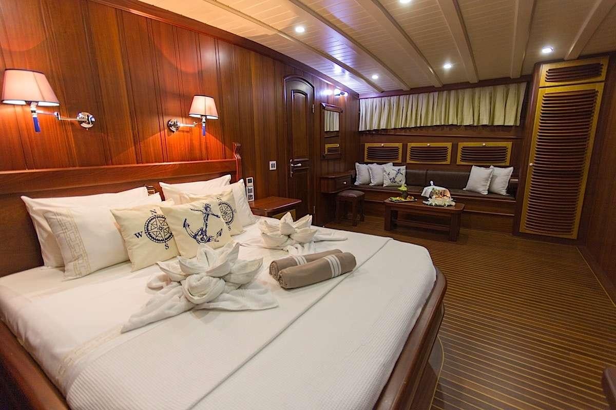 a hotel room with a bed and a couch aboard PRINCESS KARIA II Yacht for Charter