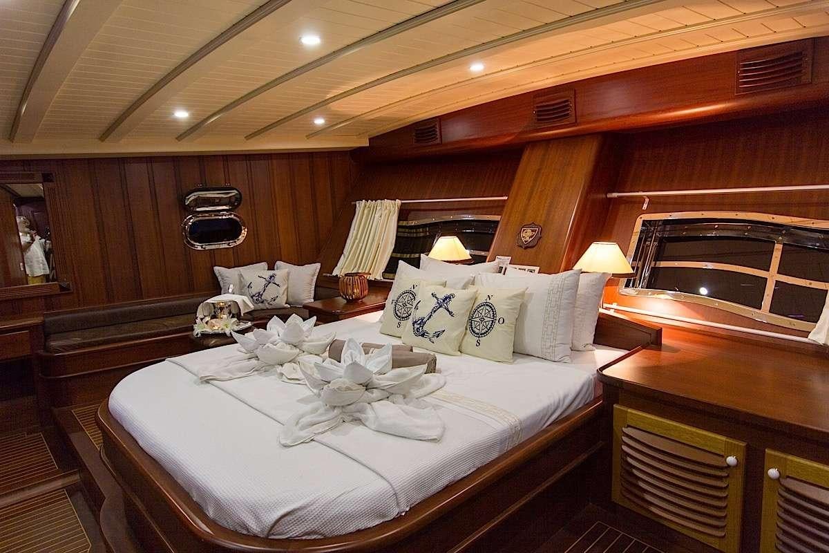 a bed with white sheets and pillows aboard PRINCESS KARIA II Yacht for Charter