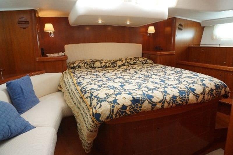 a bed with a blue comforter aboard CAPRICE Yacht for Charter
