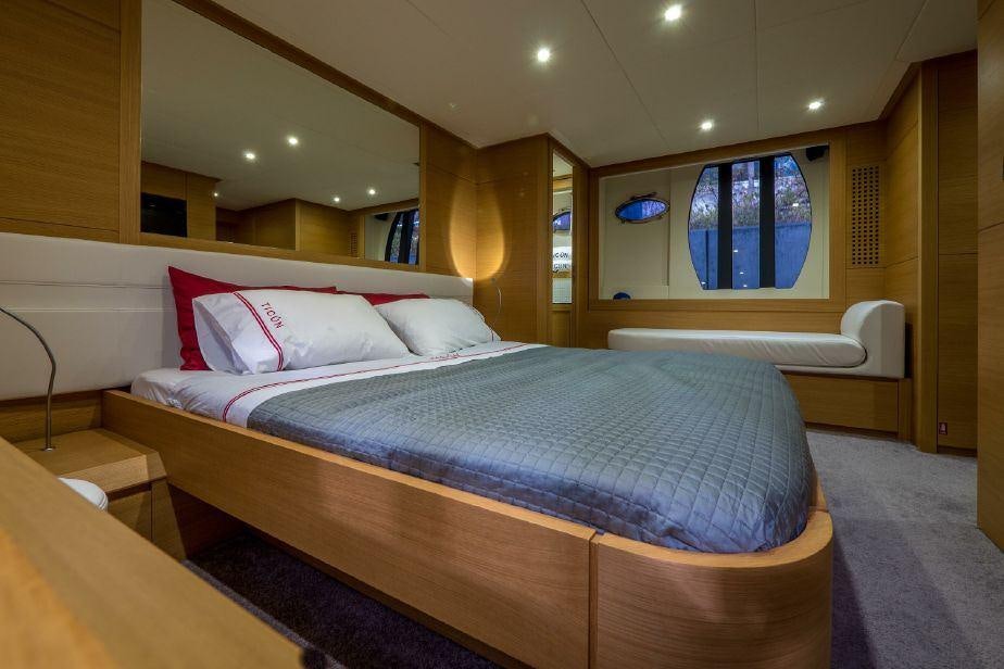 a bed with a blue comforter aboard TICUN Yacht for Charter