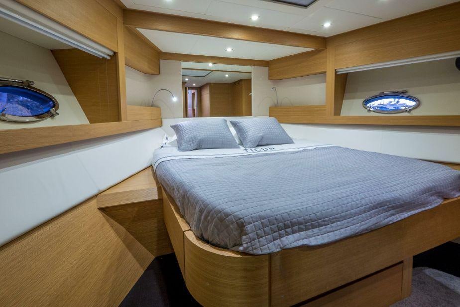 a room with a bed and a mirror aboard TICUN Yacht for Charter