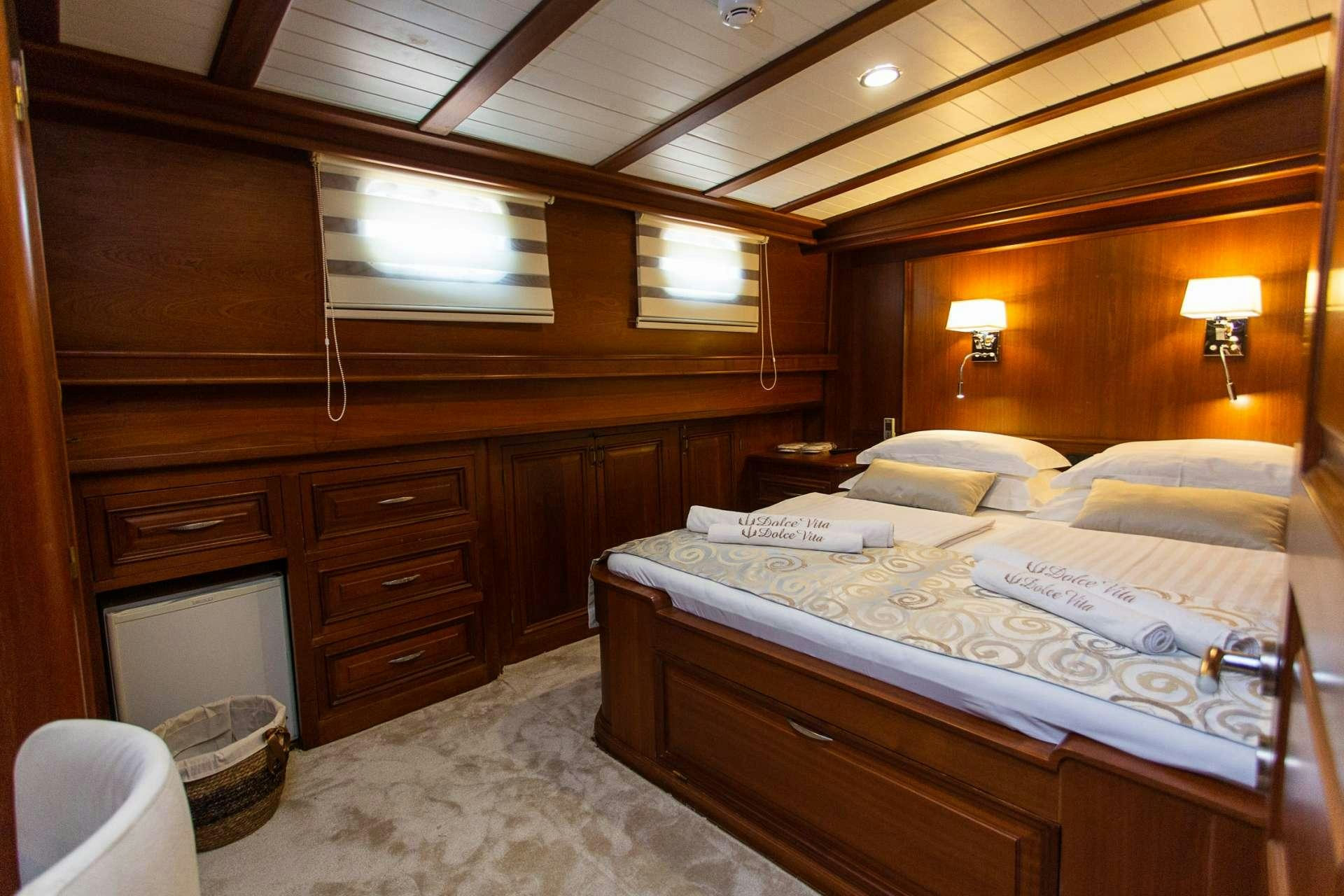 a room with a bed and a dresser aboard DOLCE VITA Yacht for Charter