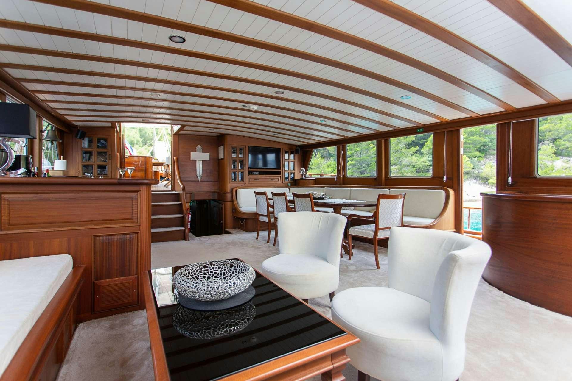 a large cabin with a table and chairs aboard DOLCE VITA Yacht for Charter