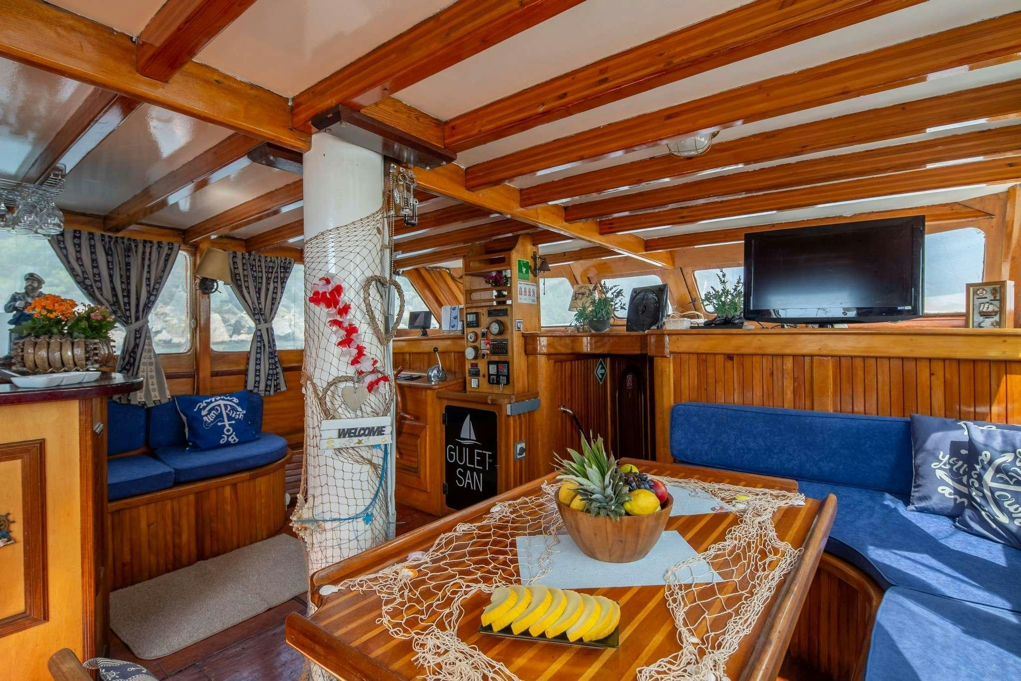 a living room with a table and couches aboard San Yacht for Charter