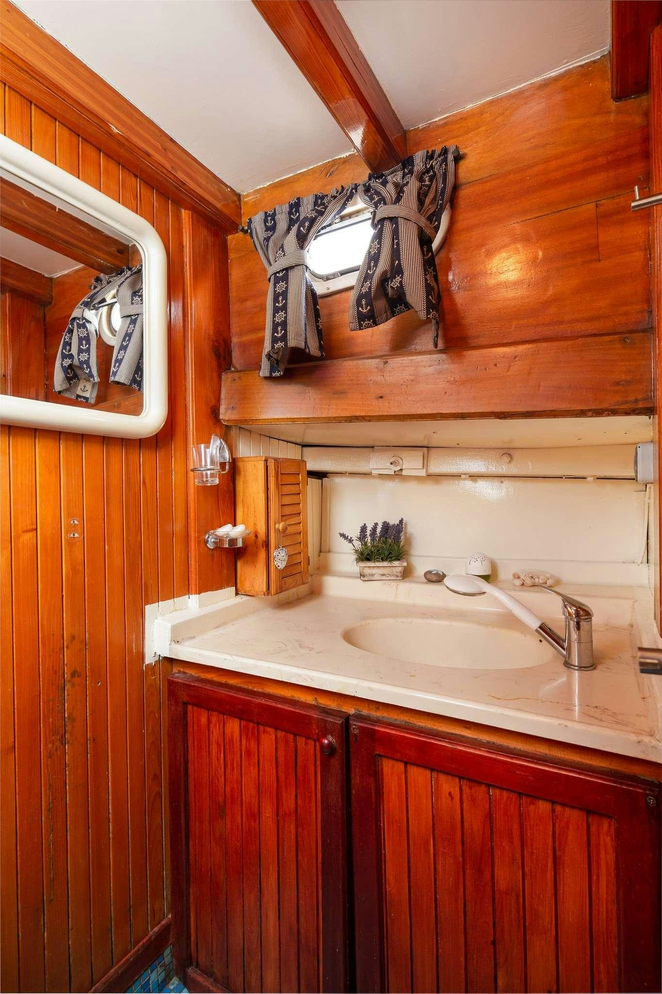 a bathroom with a sink and a mirror aboard San Yacht for Charter