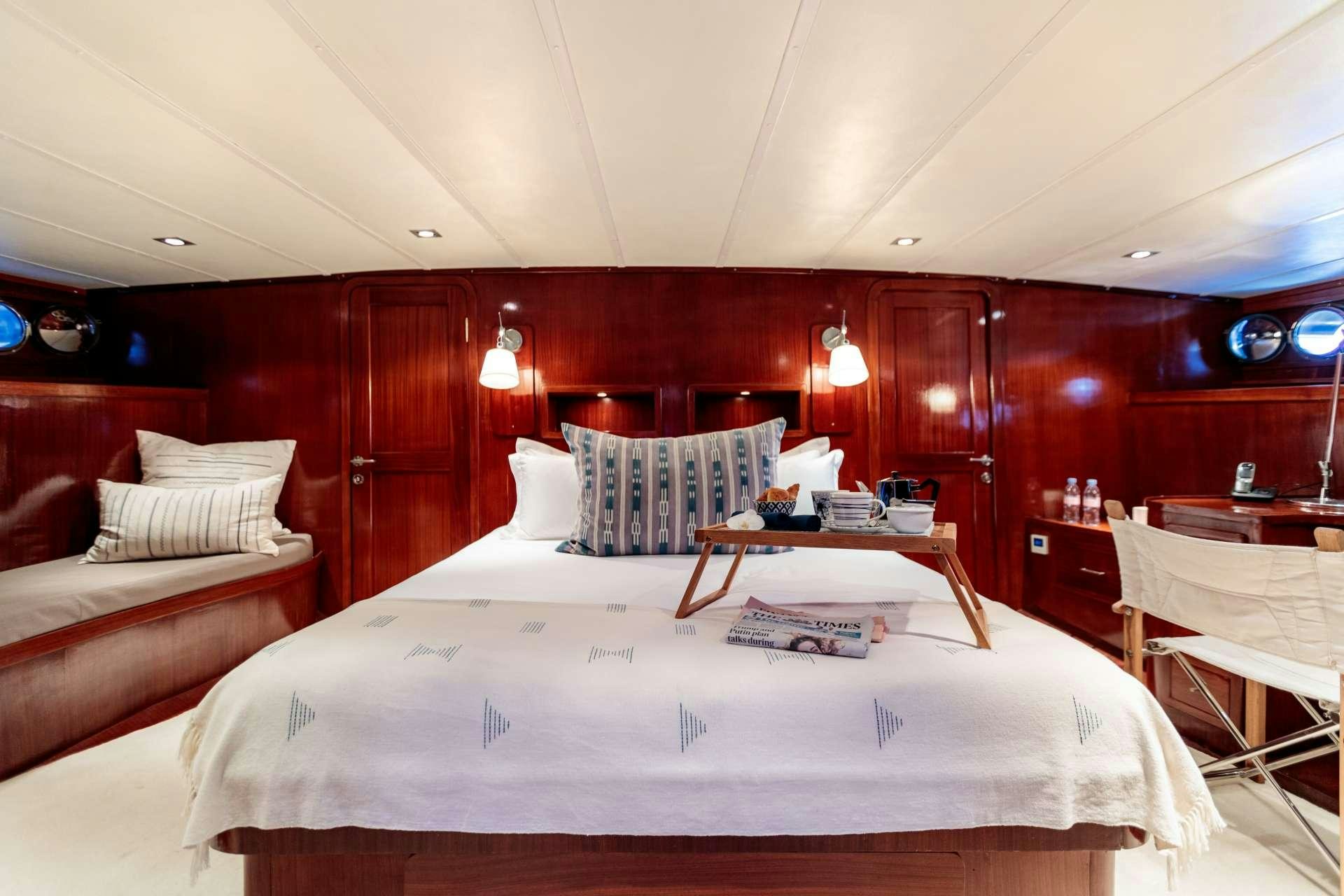 a room with beds and a couch aboard VITA DOLCE Yacht for Charter