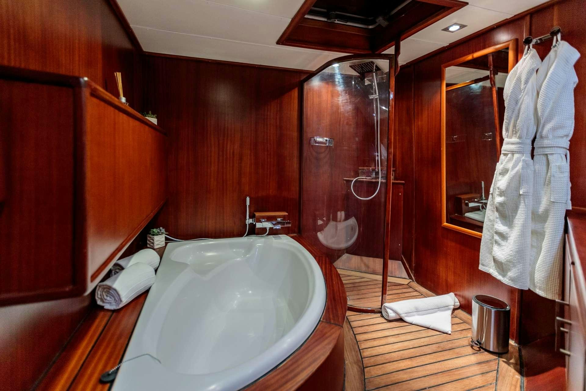 a bathroom with a bathtub and shower aboard VITA DOLCE Yacht for Charter