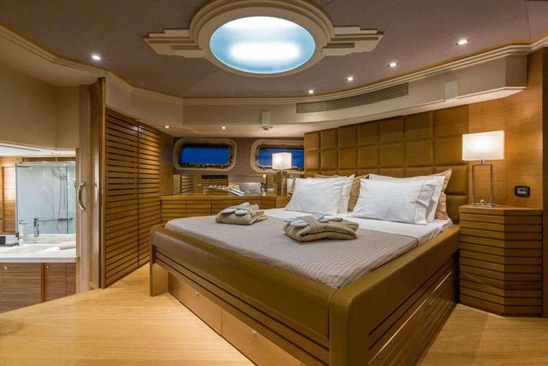 a room with a bed and a desk aboard HEESEN Yacht for Charter