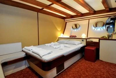 a bedroom with a bed and a mirror aboard ELARA 1 Yacht for Charter