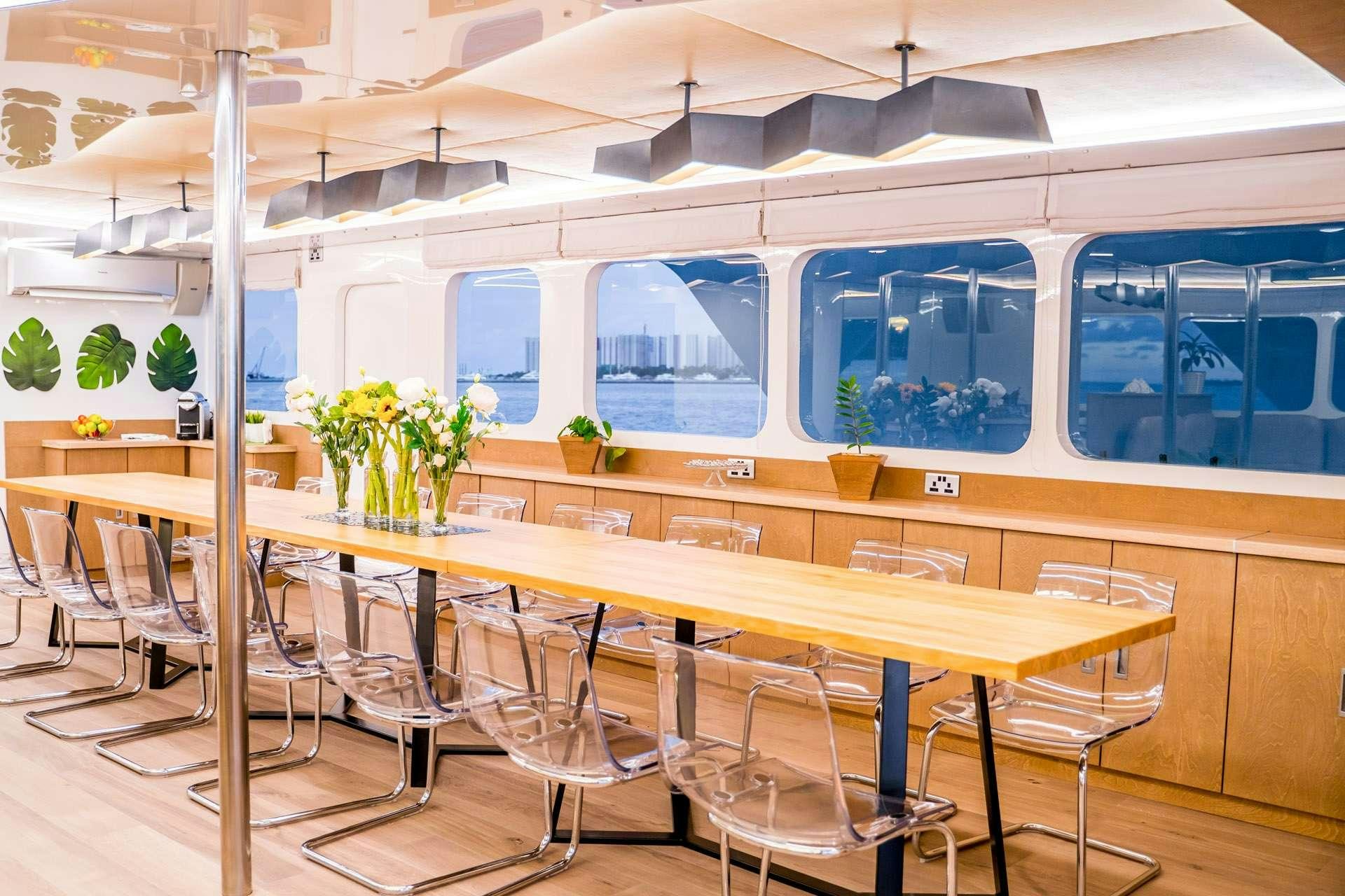 a long table with chairs and a long white table with white chairs aboard ALICE Yacht for Charter